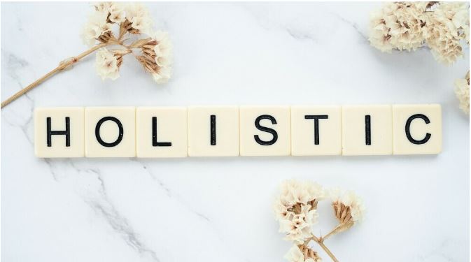 Scrabble blocks spelling the word "Holistic" against a tile backdrop